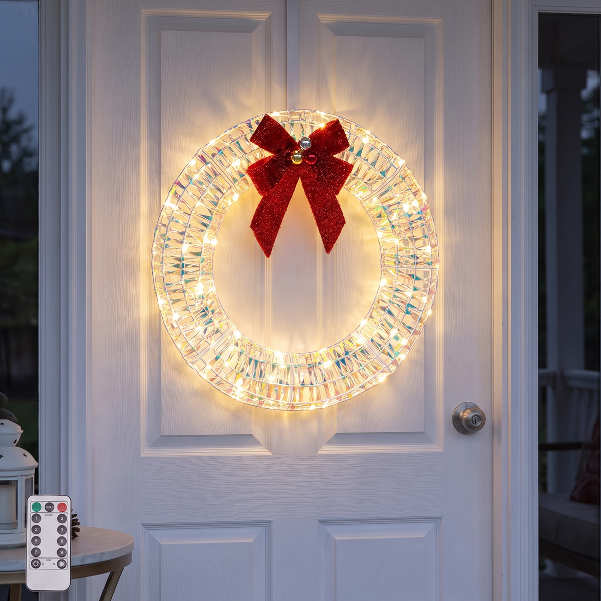 Iridescent pre-lit wreath with red bow on a front door